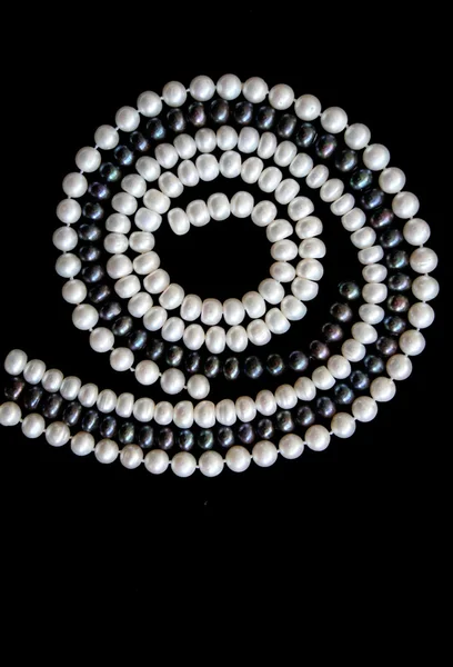 Perlas blancas y negras sobre un terciopelo negro — Foto de Stock