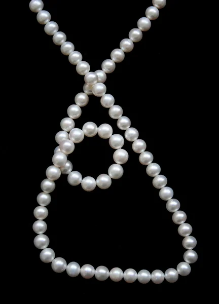 Bílé perly na černém sametu — Stock fotografie