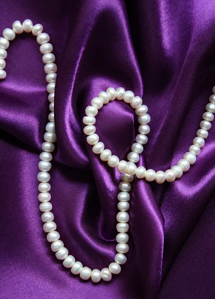 White pearls on a lilac silk background — Stock Photo, Image