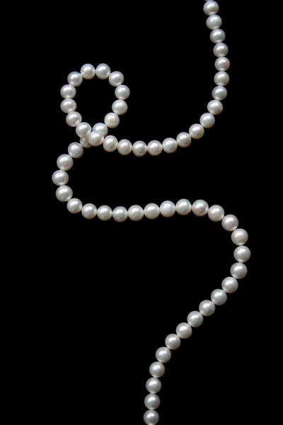 Perlas blancas sobre un terciopelo negro — Foto de Stock