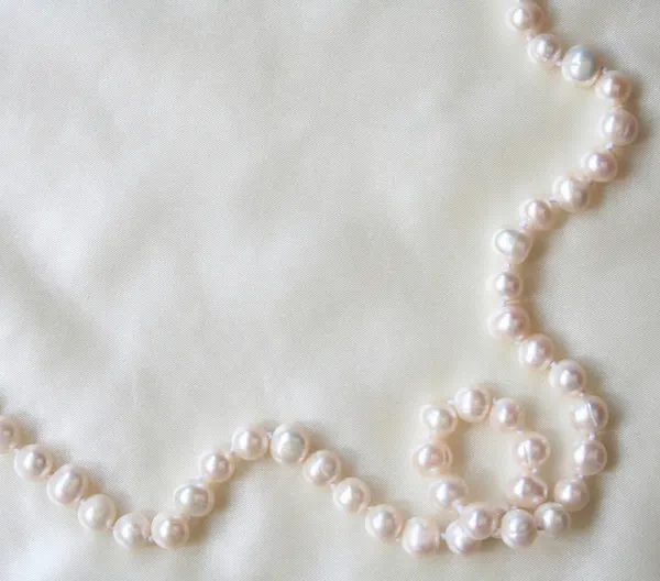 White pearls on the white silk — Stock Photo, Image