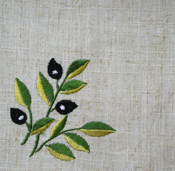Bordado de ramo de azeitona em tecido bege de linho — Fotografia de Stock