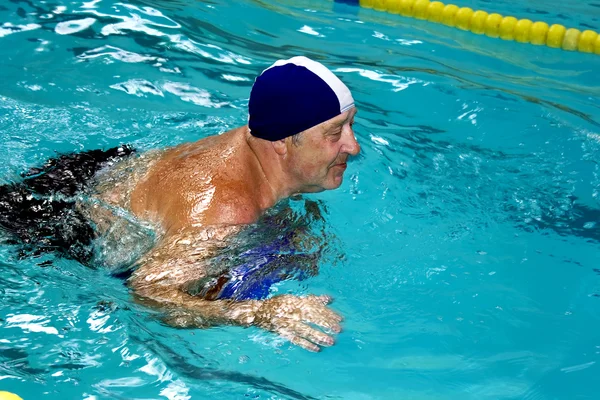 Активный счастливый пенсионер в бассейне — стоковое фото