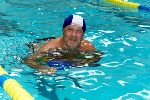 Actieve gelukkig senior man in zwembad Stockfoto