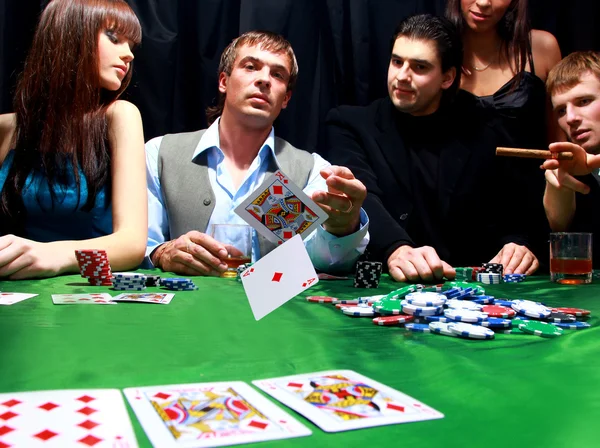 Junger Mann wirft Chips auf den Tisch, während er Karten spielt — Stockfoto