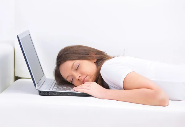 Jovem mulher de negócios dormindo no sofá, laptop descansando no estômago — Fotografia de Stock