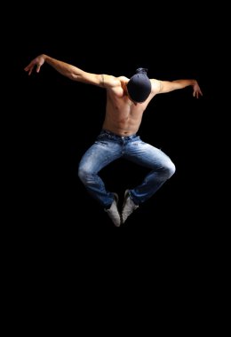 Modern dancer poses in front of the old dirty wall clipart