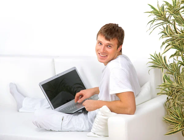 Portret van een jonge man op zoek weg terwijl u werkt aan laptop — Stockfoto