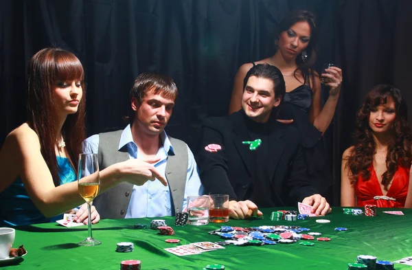 Junge Frauen werfen Chips auf den Tisch, während sie Karten spielen — Stockfoto