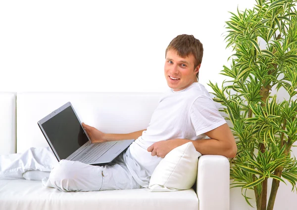 Студент отдыхает со своим ноутбуком на диване — стоковое фото