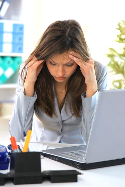 Yuong mujer sosteniendo cabeza en dolor en la oficina — Foto de Stock