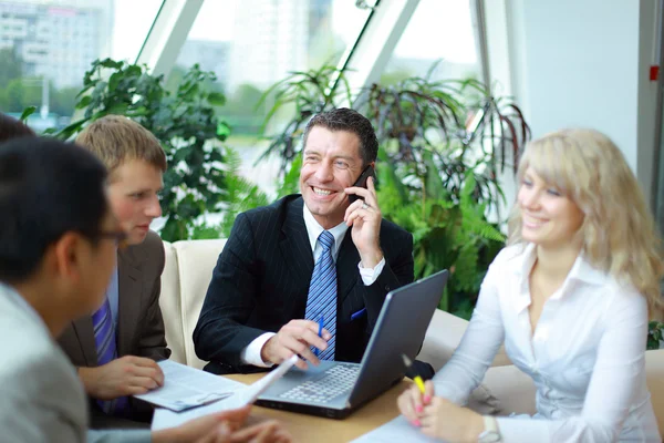 Hombre de negocios hablando por teléfono mientras estaba en una reunión — Foto de Stock