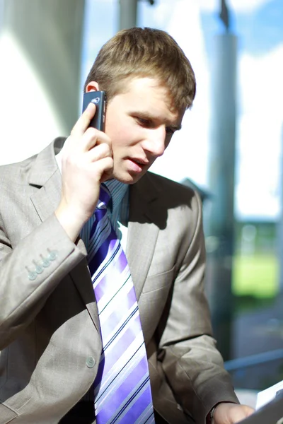 Happy young business man talking on a mobile phone — Stock Photo, Image