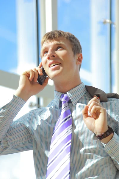 Ritratto di uomo d'affari felice che parla sul cellulare nell'atrio dell'ufficio — Foto Stock