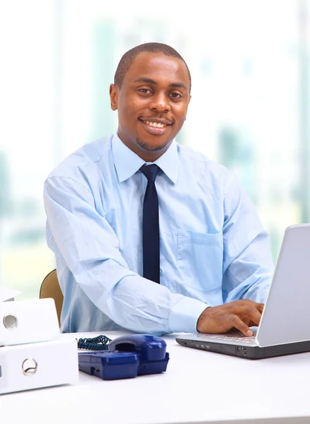 Portret van een knappe jonge zakenman met een laptop — Stockfoto