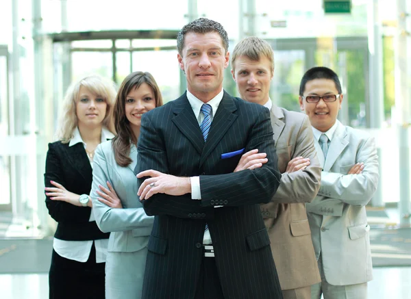 Confiado hombre de negocios maduro con colegas en el fondo — Foto de Stock