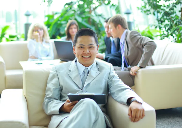 Asiático homem de negócios com colegas em uma conferência em segundo plano — Fotografia de Stock