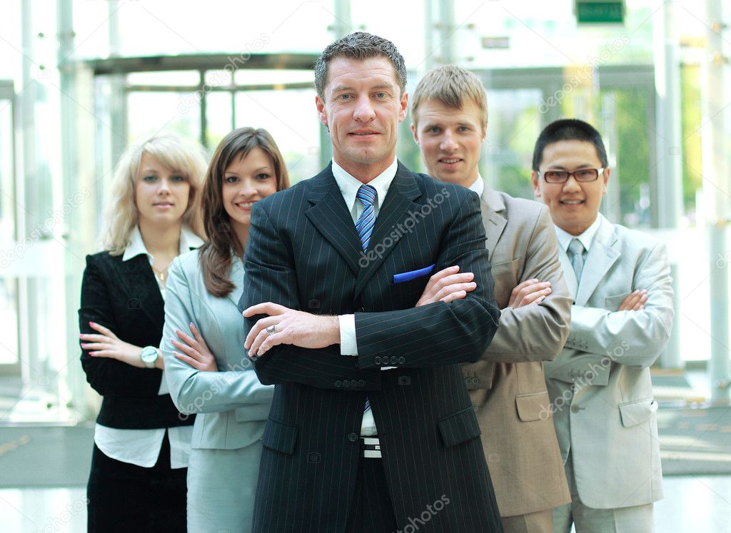 Confident mature business man with colleagues at the background