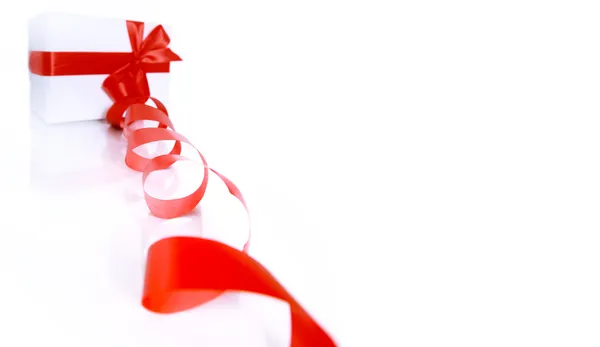Подарок, завернутый красной лентой на белом фоне — стоковое фото