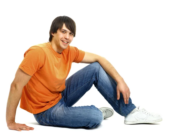 Retrato de um jovem casual satisfeito sentado relaxado. Isolado em branco — Fotografia de Stock