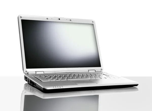 Современный ноутбук изолирован на белом с отражениями на стеклянном столе — стоковое фото
