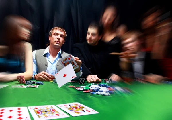 한 젊은이가 카드 놀이를 하면서 탁자 위에 과자를 던지고 있다 — 스톡 사진