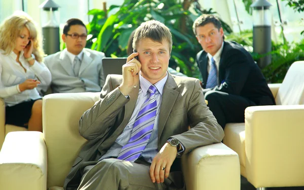 Człowiek biznesu, mówiąc na telefon komórkowy w trakcie spotkania — Zdjęcie stockowe