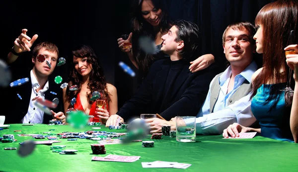 Junger Mann wirft Chips auf den Tisch, während er Karten spielt — Stockfoto