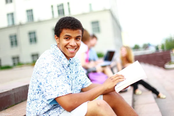 Closeup of happy young boy sitting with friends — Stock Photo, Image
