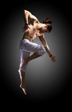 Modern dancer poses in front of the old dirty wall clipart