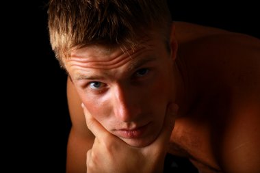 Shadowy dark close-up portrait of young good looking male model clipart