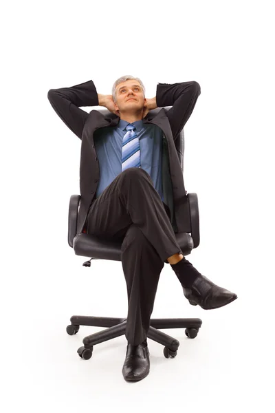 Розслаблений бізнесмен середнього віку сидить на стільці ізольовано на білому — стокове фото