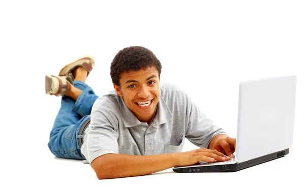 Portret van een jonge african american man met behulp van laptop op witte achtergrond — Stockfoto
