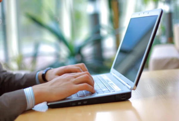 Person att skriva på en modern laptop i ett kontor — Stockfoto