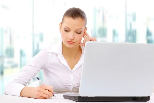 Portrait d'une adorable femme d'affaires travaillant à son bureau avec un ordinateur portable et — Photo
