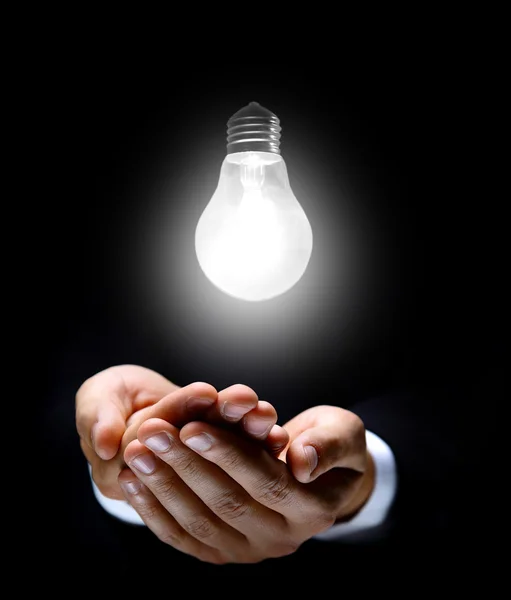 Glowing lightbulb and hand Royalty Free Stock Images