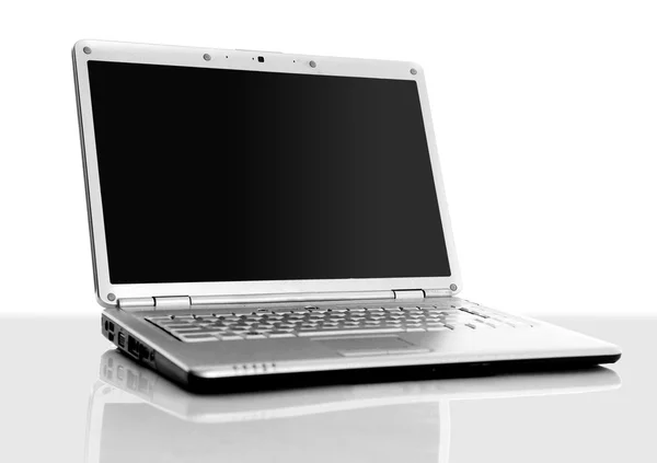Современный ноутбук изолирован на белом с отражениями на стеклянном столе . — стоковое фото