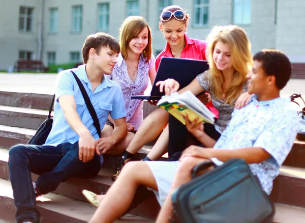 Group of five students outside sitting on steps — Stock Photo, Image