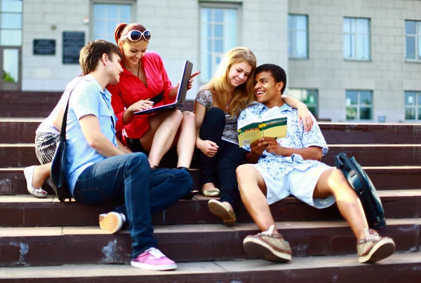 Groep van vijf studenten buiten zitten op stappen — Stockfoto
