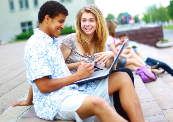Närbild av glada unga vänner använder laptop — Stockfoto