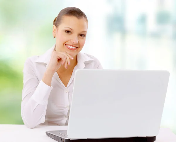 Ελκυστική γυναίκα χαμογελαστό ΝΕΩΝ ΕΠΙΧΕΙΡΗΜΑΤΙΩΝ, χρησιμοποιώντας φορητό υπολογιστή στην επιφάνεια εργασίας — Φωτογραφία Αρχείου