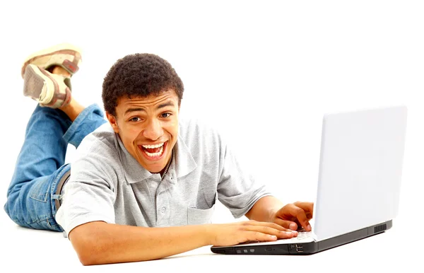 Щасливий молодий чоловік працює на ноутбуці, ізольований на білому тлі — стокове фото
