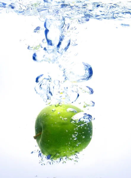 Ein Hintergrund von Blasen, die sich im blauen Wasser bilden, nachdem der Apfel fallen gelassen wurde — Stockfoto