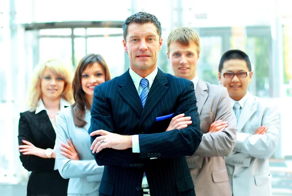 Homem de negócios maduro confiante com colegas em segundo plano — Fotografia de Stock