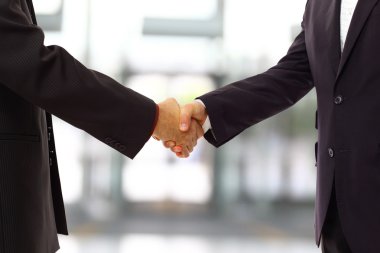 Handshake isolated on blue background clipart