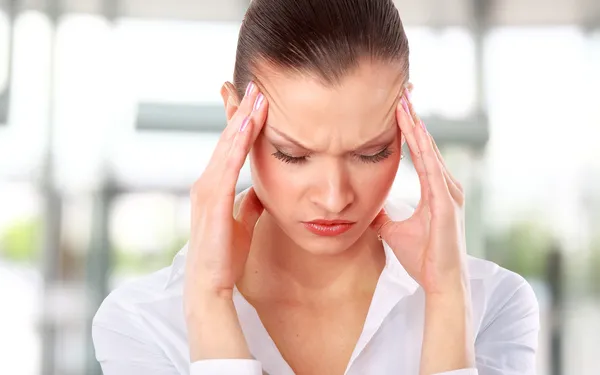 Молодая женщина страдает головной болью на белом фоне — стоковое фото