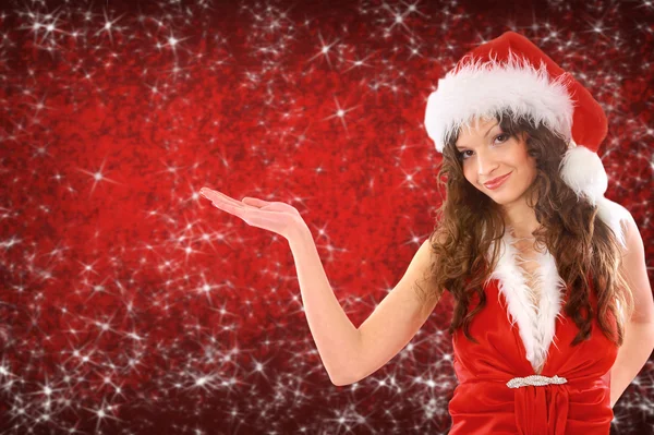Женщина, одетая как Санта с поднятой рукой, положите ваш продукт здесь — стоковое фото