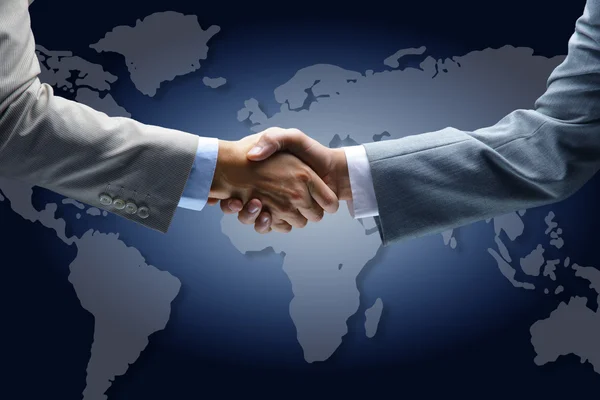 Handshake with map of the world in background — Stock Photo, Image