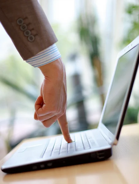 Палець вказує на клавіатуру комп'ютера ноутбука — стокове фото