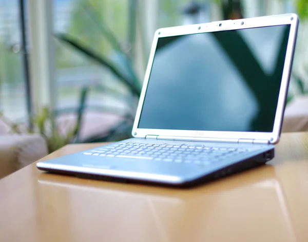 Laptop modern diisolasi dengan warna putih dengan refleksi di atas meja kaca . — Stok Foto